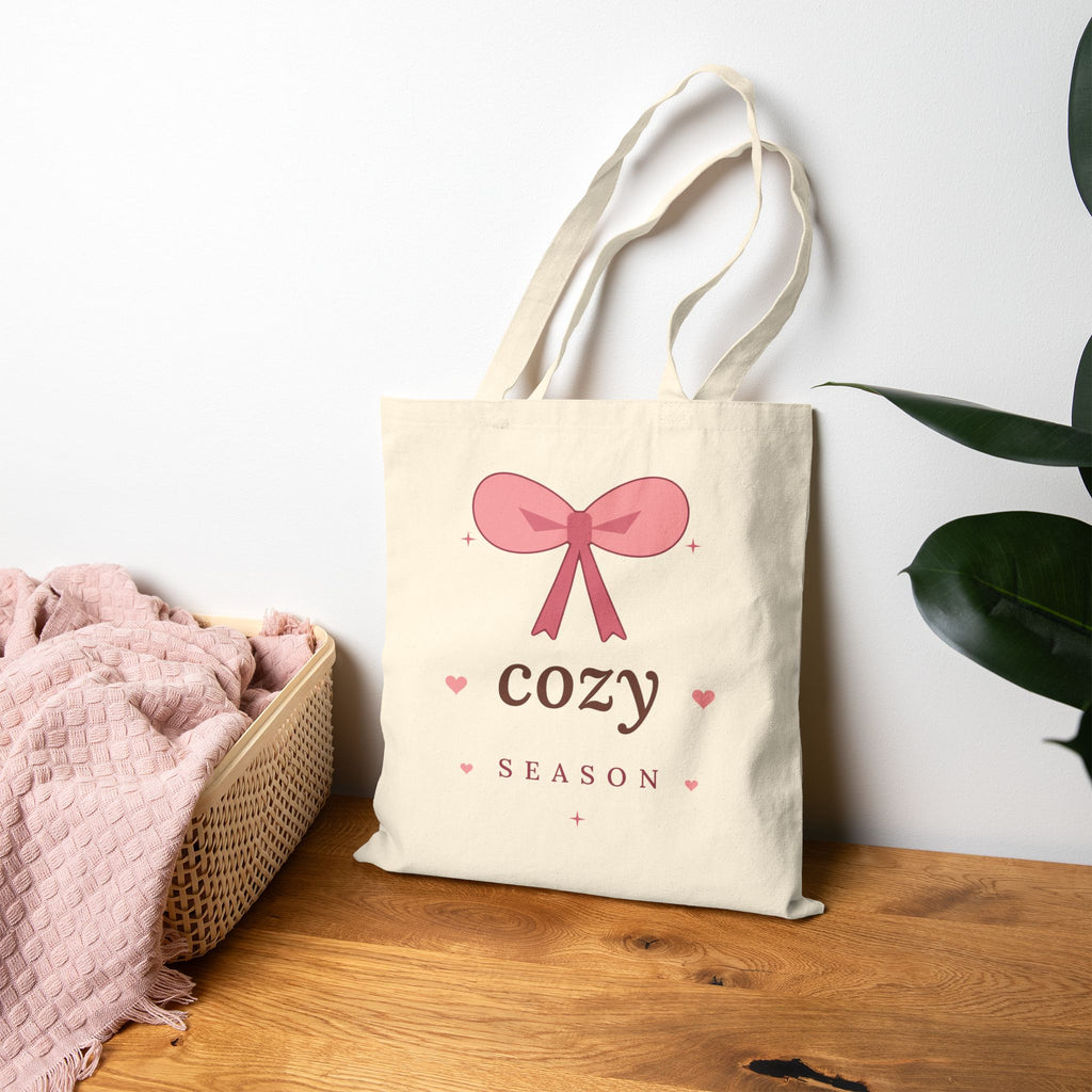 Cozy Season Canvas Tote Bag, natural, styled leaning against a wall